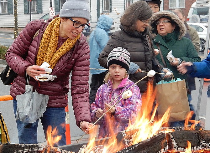 Dee Hammell helps daughter Josephine toast marshmallows for s’mores at last year’s Festival of Lights and Carols.