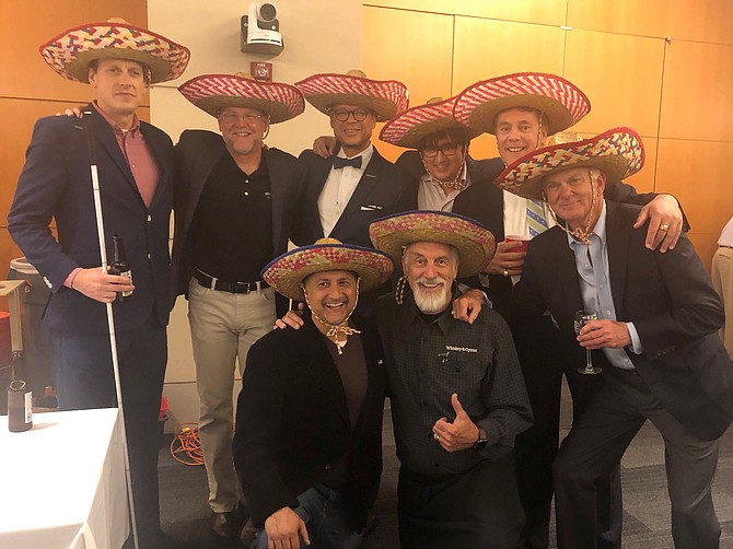 Restaurateur “Mango” Mike Anderson, bottom right, poses for a photo with friends at the Rotary Club of Alexandria’s Taste for Giving fundraiser Oct. 25 at the U.S. Patent and Trademark Office. Anderson had three of his restaurants represented at the event, including Tequila & Taco, Sweet Fire Donna’s and his latest Whiskey & Oyster.