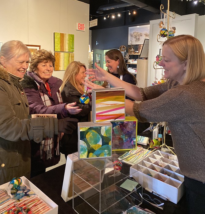 Artist Andrea Cybyk shows Marilyn Szoke, Cheyenne Cashin, Caroline Walgren and fellow artist Kat Rodgers her hand-painted ornaments at the Holiday Gallery Shop in ArtSpace Herndon during the 2019 Holiday Homes Tour of Herndon.