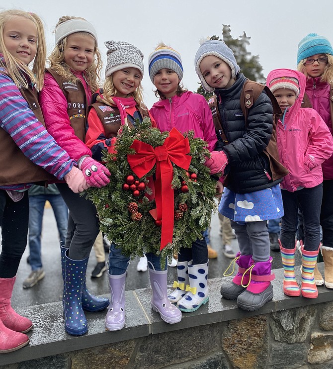 From left, Brownie Girl Scouts Troop 70091: Clare Arunski, Morgan Faust, Ellie Fair, Taylor Rommell, Abby Proudfoot, Harper Rommell, and Eleanor Beyhl hold a Remembrance wreath before the start of the Wreaths Across America 2019 ceremony at Chestnut Grove Cemetery in Herndon, Saturday, Dec. 14.