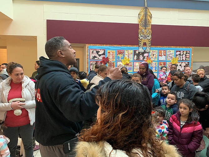 Alexandria Sheriff’s Deputy Angela Speight poses for a photo with local children during the Firefighters and Friends annual toy drive distribution Dec. 14 at Samuel Tucker Elementary School.