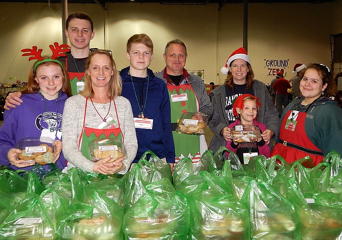 Each gift recipient received a box of handmade cookies. Manning the cookie station on delivery day are (from left) the Gunn family: Catie, Charlie, Carole, Sean and Charlie Sr.; plus Megan Girardin and daughter Julia, 7, and Mary Allison.