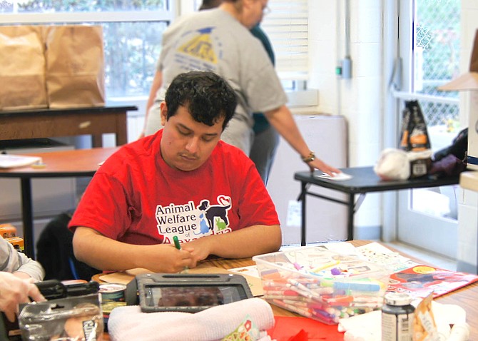 A Key Center School student works on decorating a paper bag for the AWLA’s delivery of pet supplies to homes.