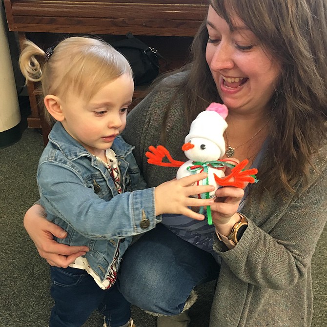 Angels Macri and her 22-month-old daughter Dorothy Ellen play with the snowman they created during the Potomac Library Build a Snowman project.