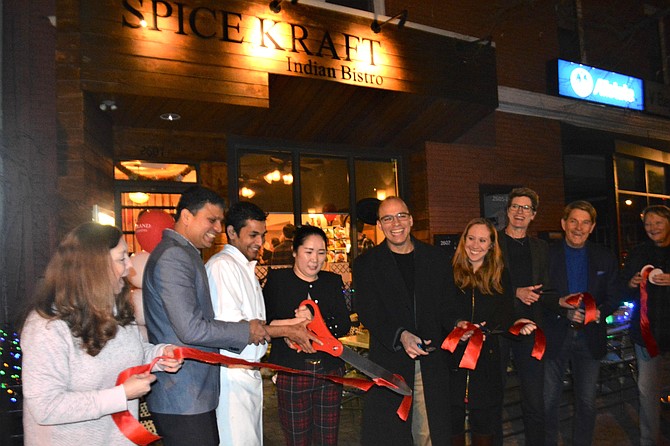 Mayor Justin Wilson, center, is joined by city officials and members of the Del Ray Business Association Jan. 20 as he cuts the ribbon to formally open Spice Kraft restaurant on Mount Vernon Avenue.