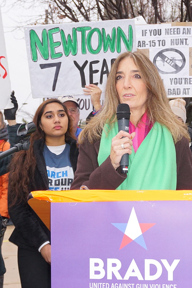 Speaker of the Virginia House Del. Eileen Filler-Corn (D-41) reminds more than 100 activists how far they have come in their fight against gun violence Dec. 14 along the sidewalk of the National Rifle Association in Fairfax.  Standing behind her is the next generation of gun violence prevention activists:  Oakton High School senior Elizabeth Paul, 17, director of diversity and inclusion for the March for Our Lives Virginia chapter.