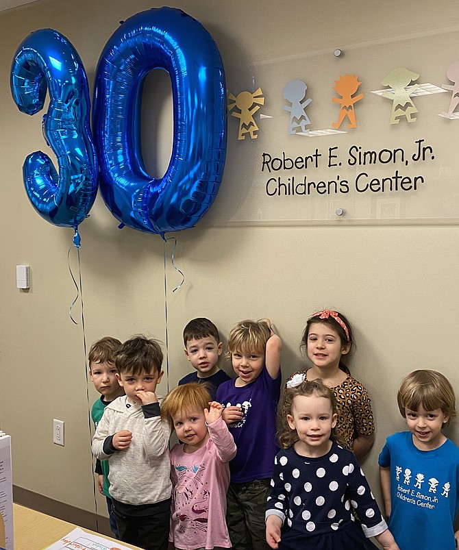 Children at the Robert E. Simon, Jr. Children's Center (from left): Nathan Weber, 2, of Vienna, Will Riordan, 4, of Reston, Campbell Catlett-Miller, 2, of Reston, Isaac Younger, 4, of Fairfax, Russell Wigen, 4, of Sterling, Beatrix Schimpf, 3, of Reston, Ava Leshock, 5, of Great Falls and Rainier Gramsky, 3, of Great Falls mark the milestone 30th anniversary of the center with big Mylar balloons soaring over their heads.