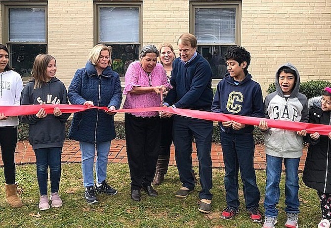 Students and City Council members Janice Miller and Jennifer Passey look on while Director Maureen Santamaria (in pink) and Fairfax Mayor David Meyer cut the ribbon on the school.