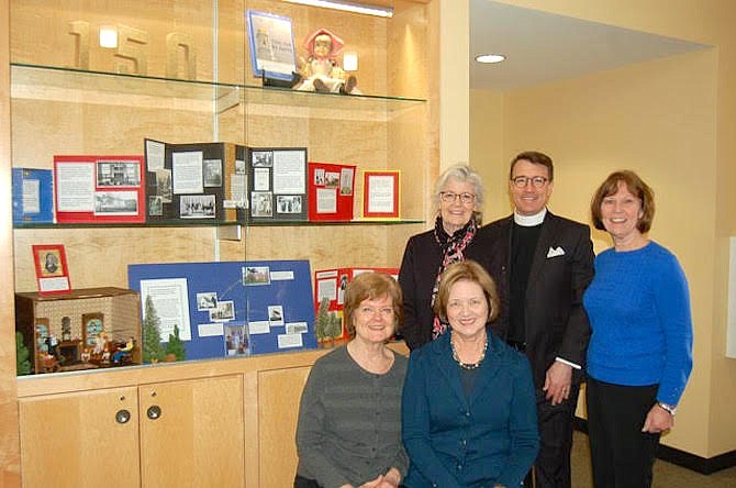History book authors Deborah Watson and Ramona Speicher (seated) and Sandy Smoot (right)  with display designer Lori Wiseman and St. John’s Episcopal Church’s new rector The Rev. Joshua Walters at the display featuring the church at Dolley Madison Library.
