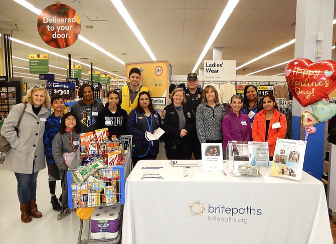 Some of the Stuff the Bus participants, from left: Diane Lobasso and children Charlie and Courtney; Natasha Nunn and daughter Zoe; Walmart employees Andrew Sanza and Arati Sigdel; police officers Reanna Jacobson and Todd Givens; Britepaths’ Christina Garris; Volunteer Fairfax’s Shelley Brosnan; and CSP’s Monica Obozele and Arathi Krishendra.
