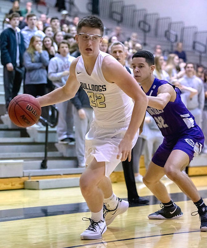 Chase Whippon #22 looks to the basket as he dribbles the ball.