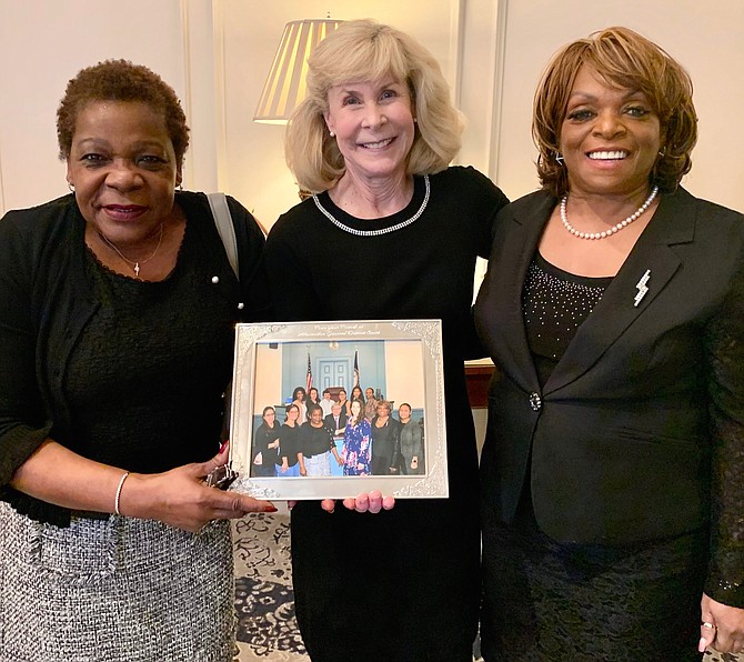 District Court Judge Becky Moore, center, is presented a photo by General District Court clerks Marion Jackson and Hope Mayfield at Moore’s retirement luncheon Jan. 31 at Belle Haven Country Club.