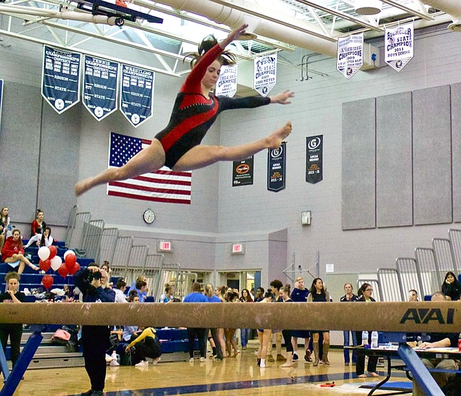 Gymnast Kerry Gallagher of Herndon High School performs a split leap on beam at Chantilly High School.