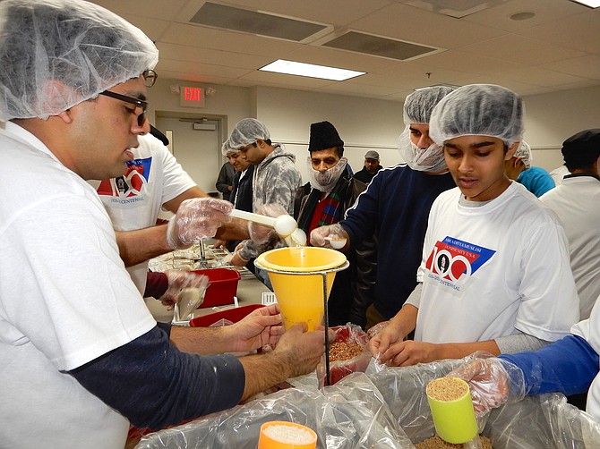 (From left) Danisch Malik and Hamza Qumar wear their centennial celebration T-shirts while they work.