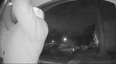 The doorbell camera picture shows the suspect taking a picture through the door transom window.