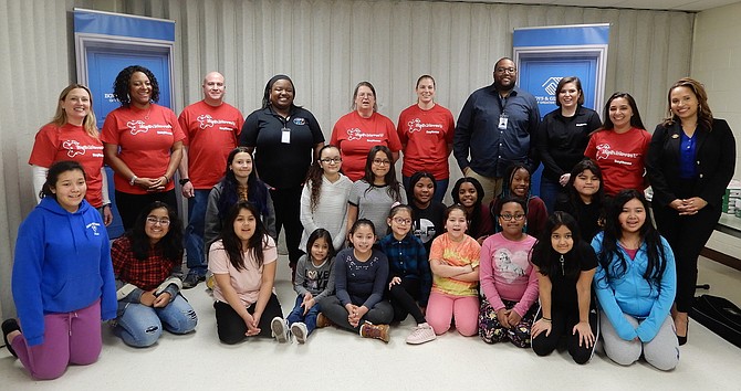 The Raytheon employees, Boys & Girls Club leaders and local children gather for a group photo at the event’s end.