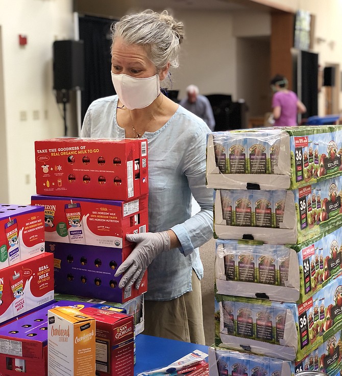 During the COVID-19 crisis, volunteer pantry co-leader, Amy Shaw, readies donations at Good Shepherd Lutheran Church in Herndon for distribution by the South Lakes High School Parent Teacher Student Association Food Pantry.