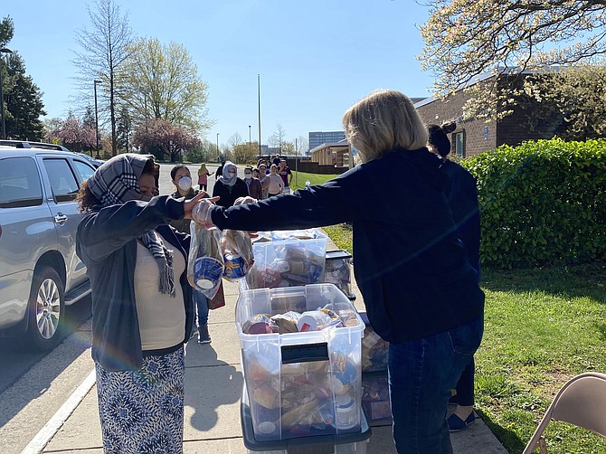Food for Neighbors staff distributes weekend food bags to students or parents of students in Fairfax County Public Schools' Herndon Pyramid.