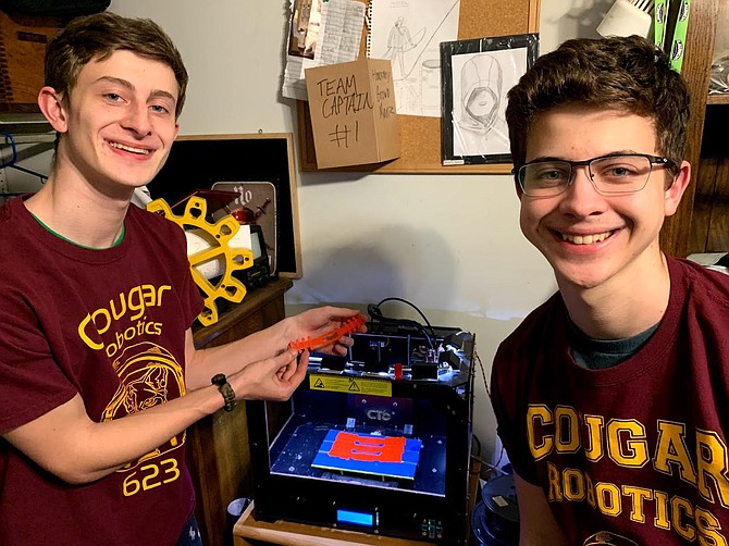 Oakton Robotics & Engineering Student at ODU Benjamin Yusman, and Oakton Junior & Robotics Team Build Lead Alexander Yusman, making surgical mask straps.