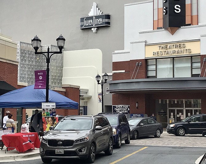 Cars drive up on Boardwalk Place in Rio in Gaithersburg to receive free meals from Silver Diner and Real Food for Kids.