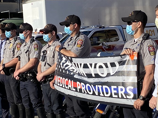 The Fairfax County Police Motor Squad holds up their banner of appreciation to medical providers at Reston Hospital Center.