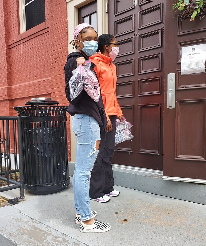 Rhyan Goozh, Bullis freshman, left, arrives at Stepping Stones Shelter in Rockville with masks for those in need. Rhyan made the masks with the help of her grandmother using old sheets.