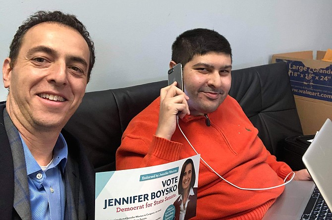 After suffering a knee and spine injury, Toora Arsala still shows up to make phone calls for a candidate. Here, he is pictured with Del. Marcus Simon (D-53).