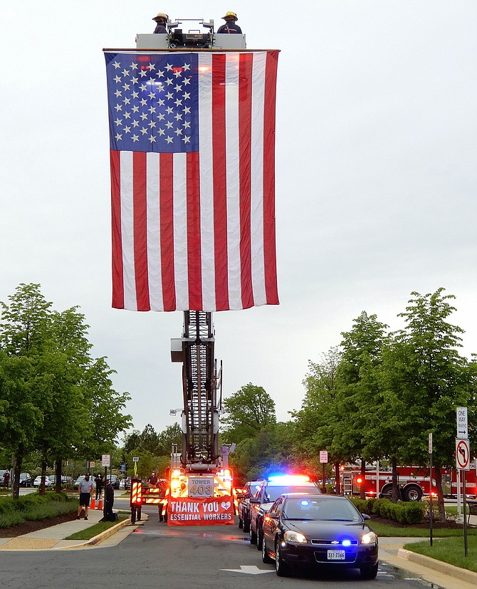 Fairfax City Fire Station 3’s tower ladder truck displays a huge American flag to honor the staff of Inova Fair Oaks Hospital.