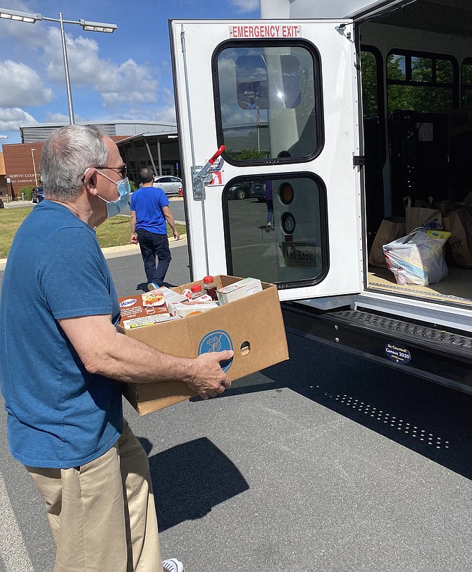 Here comes Jay Hadlock with another box of food to load up for Stuff the Bus, held at the North County Government Center in Reston.