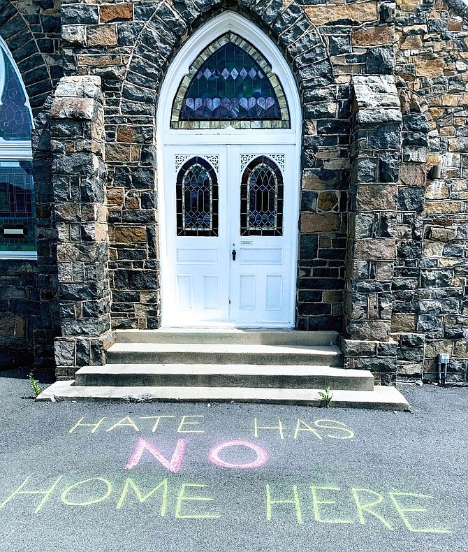 HATE HAS NO HOME HERE is marked in chalk outside of First Baptist Church Herndon supporting A Stand Against Cowardice.