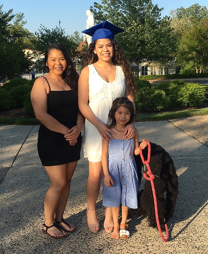 Evelyn Esteban, center, of Arlington, wasn’t going to let a virus stop her from the traditional photographs of her on campus in cap and gown. Esteban majored in Psychology. She will follow up her degree with further study of Industrial Psychology. Her sister, Karen, accompanied her as did Evelyn’s daughter, Adrianna, 5. Esteban was all smiles as she enjoyed the moment. A single mother and the first person in her family to graduate from college, she was feeling very proud. She said it was hard during the last two months with “zoom” classes and isolation, but she made it.