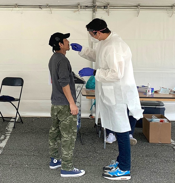 A COVID-19 test is administered by the Alexandria Health Department during the free community testing event May 25 at the Cora Kelly School for Math, Science and Technology.