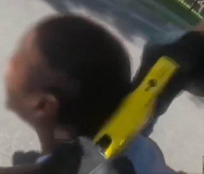 A Fairfax County Police Officer deploys an electronic control weapon, shooting an African American male after other county officers and paramedics had been working on getting him into an ambulance.