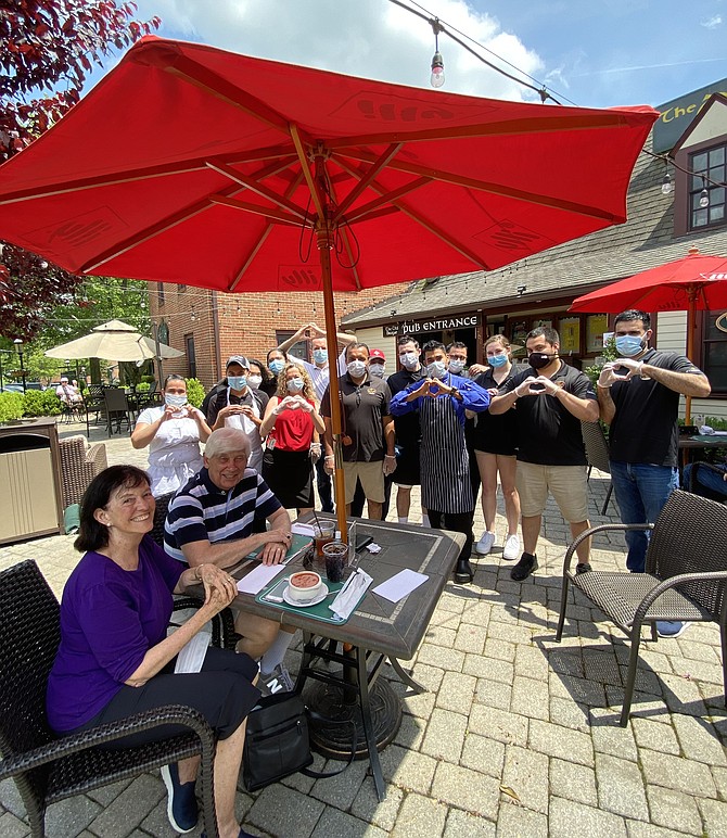 Michael J. Kearney, proprietor of The Old Brogue (back row, third from left) joins Franz and Sally Jaggar as they enjoy their lunch outdoors during Phase One of Governor Northam's reopening plan. Restaurant manager, Frances Duggan (front row, third from left), Kearney and staff show heart hands appreciation to all.