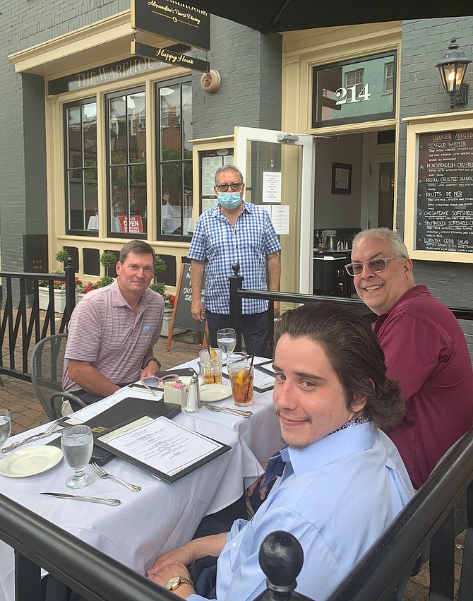 Warehouse Restaurant owner Hossein Pishdad, standing, serves a meal to Craig Dyson, John Moorman and Taylor Barnes June 3 in Old Town. Indoor dining will resume beginning June 12 as part of Phase Two of the Virginia Forward plan.