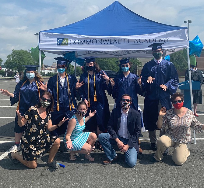 Dressed in caps and gowns, seniors Hazel Feldstein, Ewan O’Donnell, Lucy Souilliere, Max Leopold, and Mattias Camacho, together since 3rd grade, celebrate their graduation from Commonwealth Academy during a drive-in ceremony June 5 at Potomac Yard. In front are teachers Jane Furey, Rose-Marie Parker, Santiago Sere and Ksenya Litvak.