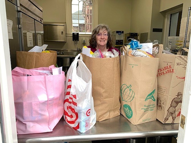 Anne Ramsey hands out prebagged groceries from the Meade Room at Historic Christ Church at their last pop-up pantry on March 19 before the coronavirus shut down the weekly event. Daily food deliveries to people in need have replaced the pantry.
