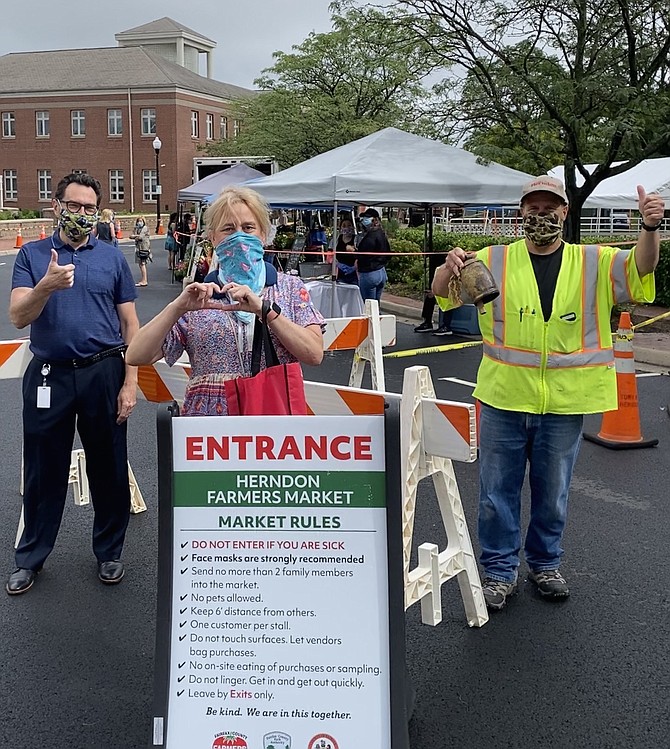 Farmers Market Manager John Dudzinsky opens the Herndon 2020 Fairfax County Park Authority Farmers Market at Herndon, by clanging his big cowbell. Joining him are Town of Herndon Vice Mayor Sheila Olem and Scott Robinson, Public Works.