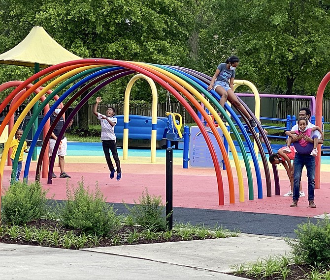 A group of children playing at Clemyjontri Park while wearing masks.