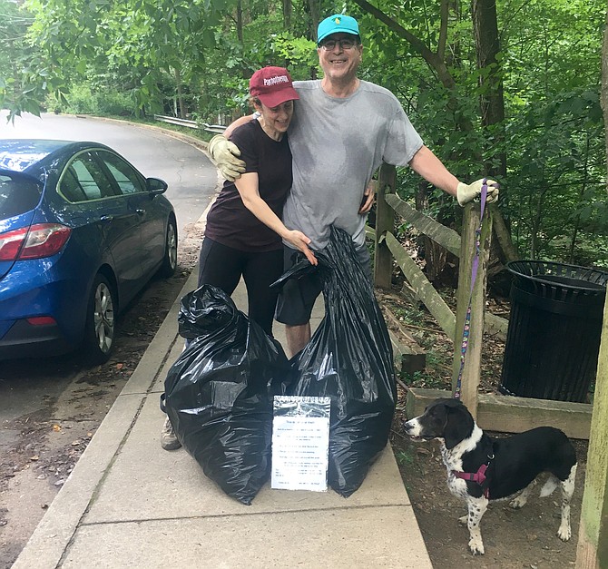 Karen Hannigan and Joe Schwartz, of Bluemont and Lyon Park neighborhoods, with their full garbage bags and their dog, Sadie, after a morning’s work picking up trash.