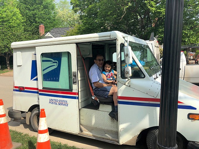 Jesus Collazos in his mail truck with his first granddaughter, Juliana Collazos.