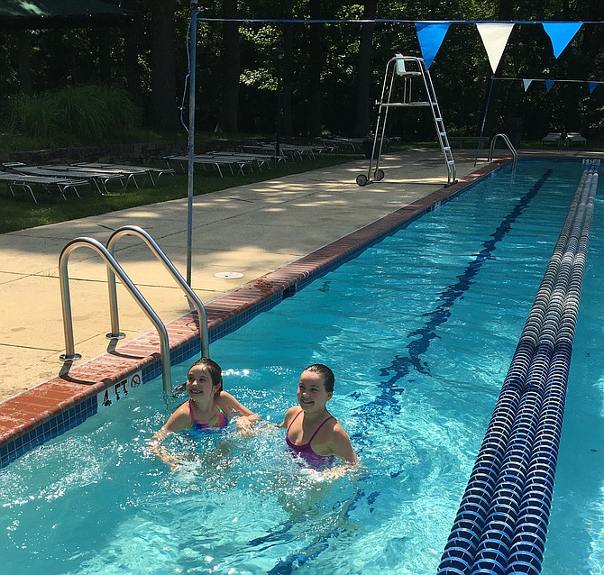 Sisters Grace, left, and Julie Zettler play together Monday, the first day Potomac Swim and Tennis Club opened its pool.