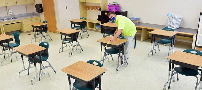 An FCPS employee prepares a classroom for In-Person Instruction with Social Distancing, one of two plans for academic year 2020-21.