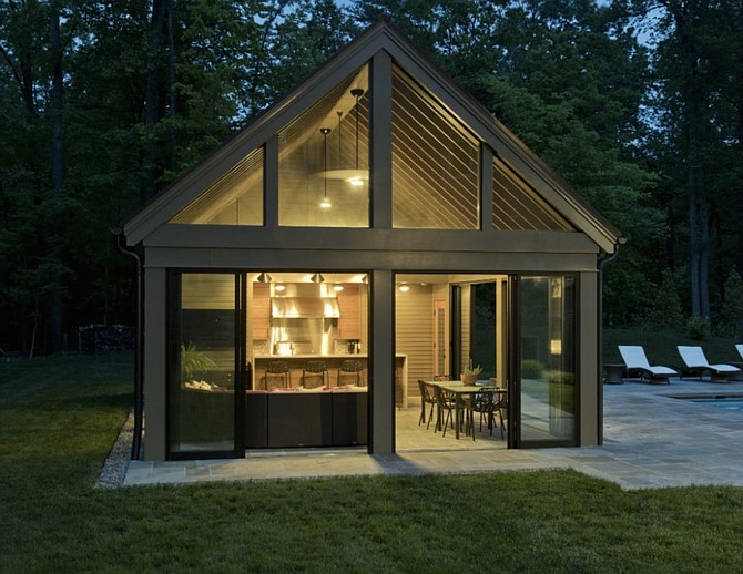 Three of the four walls of the pool house are made of glass and give the space a rustic feel.