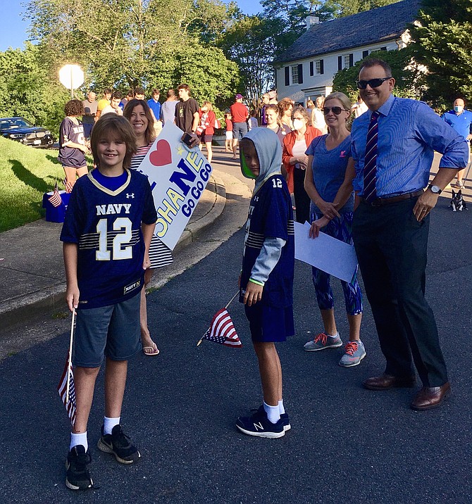 Neighbors Brandy and Jeff and two sons Jay, 10, and Graham, 9, were in the Navy spirit. Jeff’s grandfather was a Navy officer. Lisa Shapiro, the organizer, is in the background holding a sign for Tomb.
