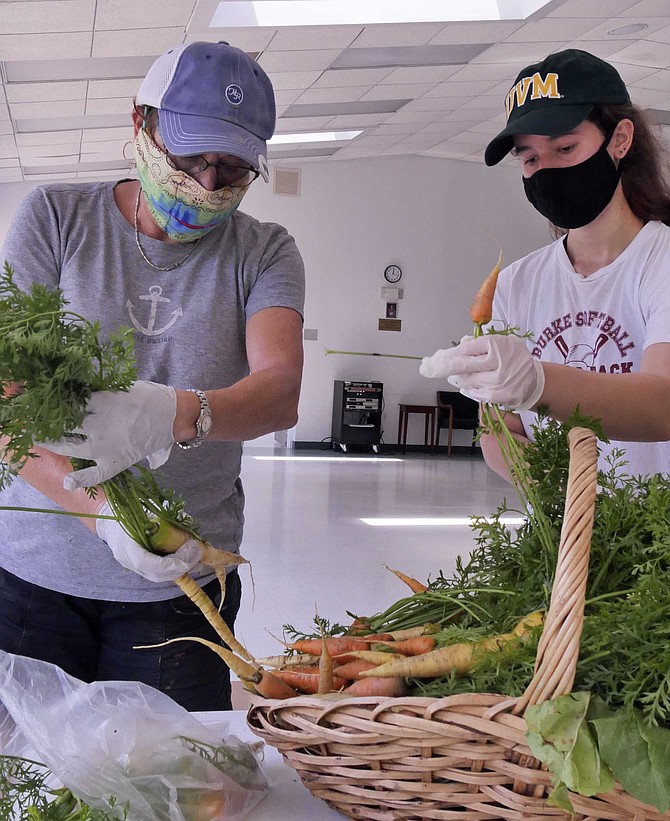 Gena Sherman and her mother, Debbie Siegel, are bagging produce donations for the fourth Monday in a row.  They divide up a basket of carrots donated by the organic garden at Potomac Overlook Regional Park where Siegel assists as a Virginia Extension Master Gardener.