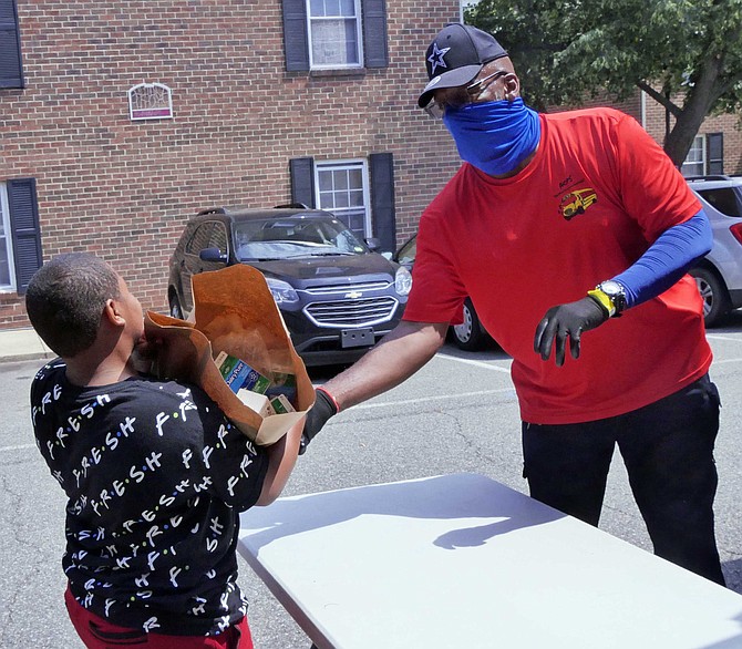 A woman drives up to pick up food for her three kids plus for her cousin’s three kids. “His car broke down today.” She leaves with two grocery bags full of lunches and breakfasts.