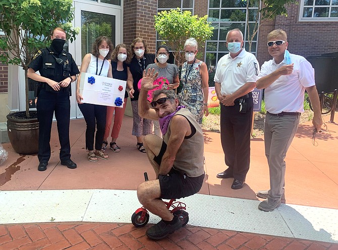 With a comic entertainer in the foreground, Synergy Home Care CEO Mitch Opalski, right, and Sheriff Dana Lawhorne, second from right, stand with Silverado Memory care staff after presenting them with gift baskets and posters of appreciation for a job well done during the COVID-19 pandemic.