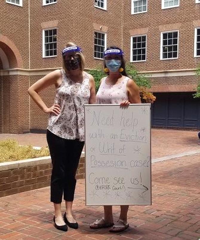 Legal Services lawyers Mary Horner and Alexandra Lydon advertise assistance for tenants facing eviction in front of the courthouse and assist filling out the 60-day affidavit.