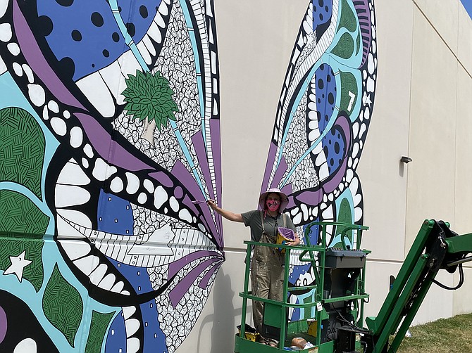 Street artist Kelsey Montague paints “Reston Wings Mural” at International Tower at Reston Heights in Reston. Commissioned by American Real Estate Partners, the work is interactive.